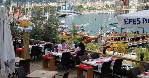 Alanya limanına bakan teras restoranda kahvaltı eden misafirler